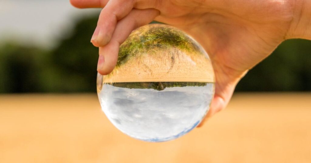 a crystal ball showing a flipped perspective on a rural field