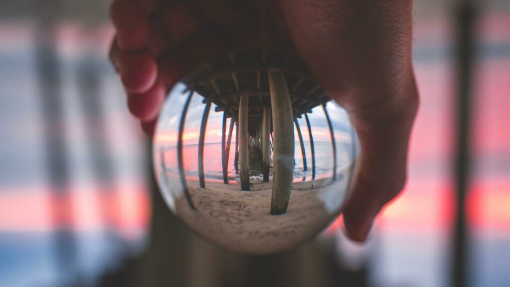A glass ball inverses the view of a pier.