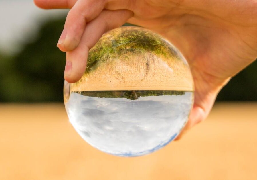 a crystal ball showing a flipped perspective on a rural field