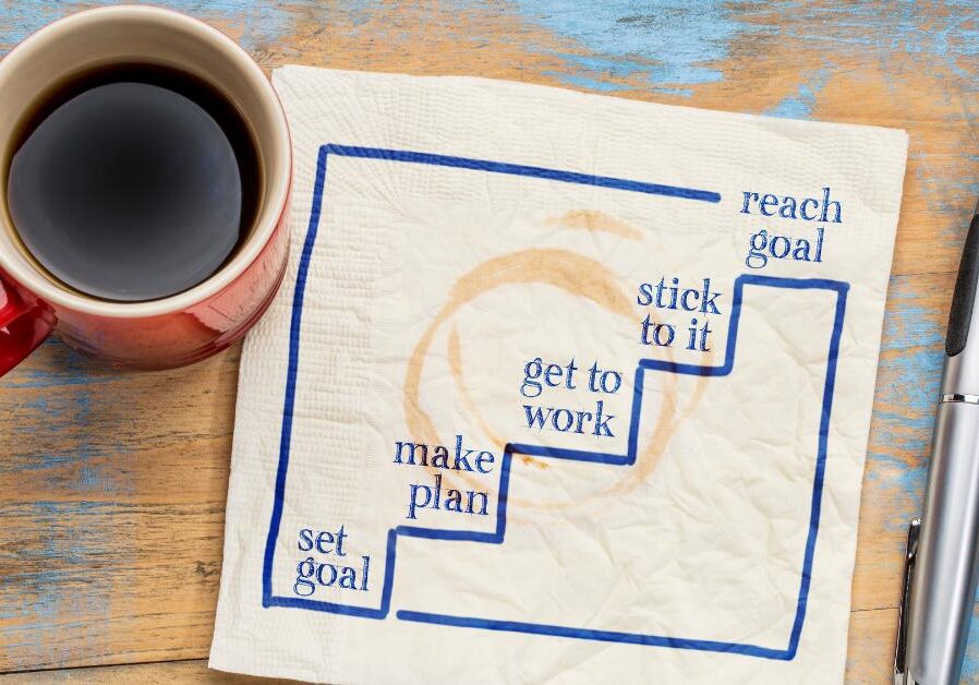 setting business goals on paper near a coffee mug