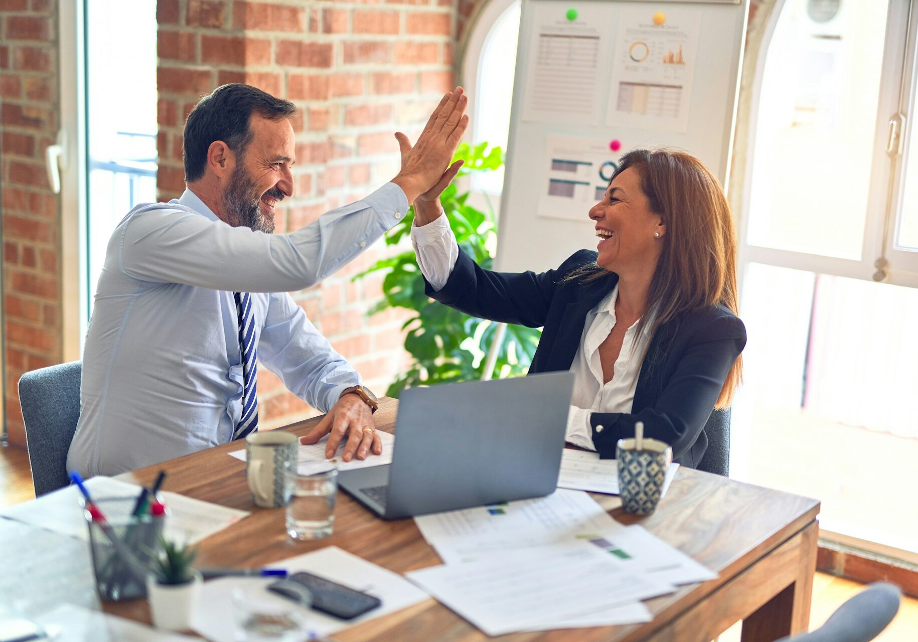 Two middle-aged business workers smiling, happy, and confident.