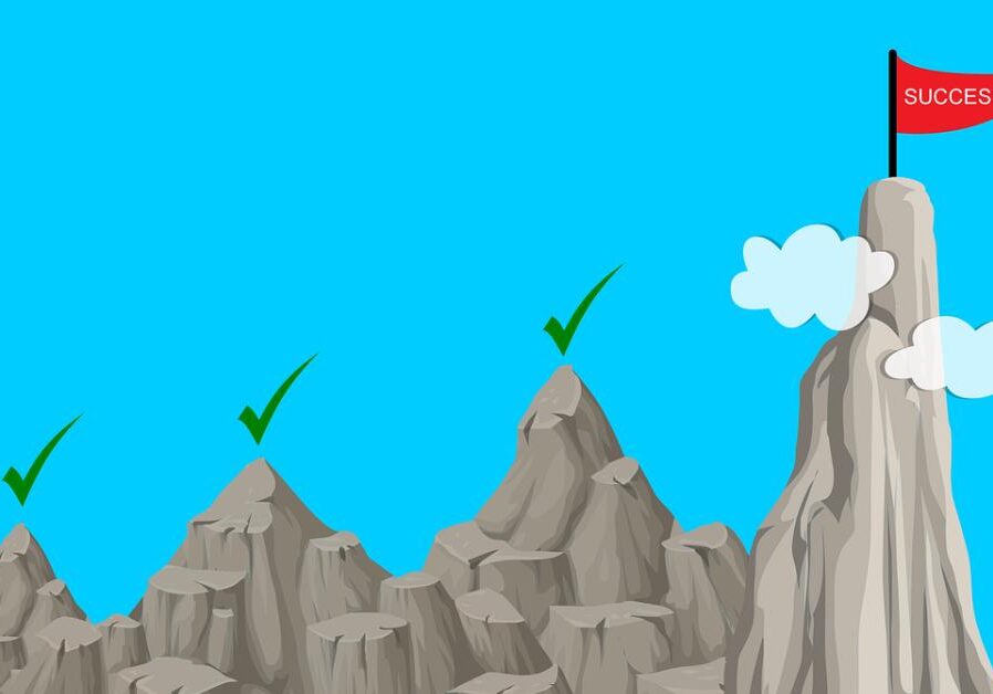 a graphic showing success as a series of mountains to summit
