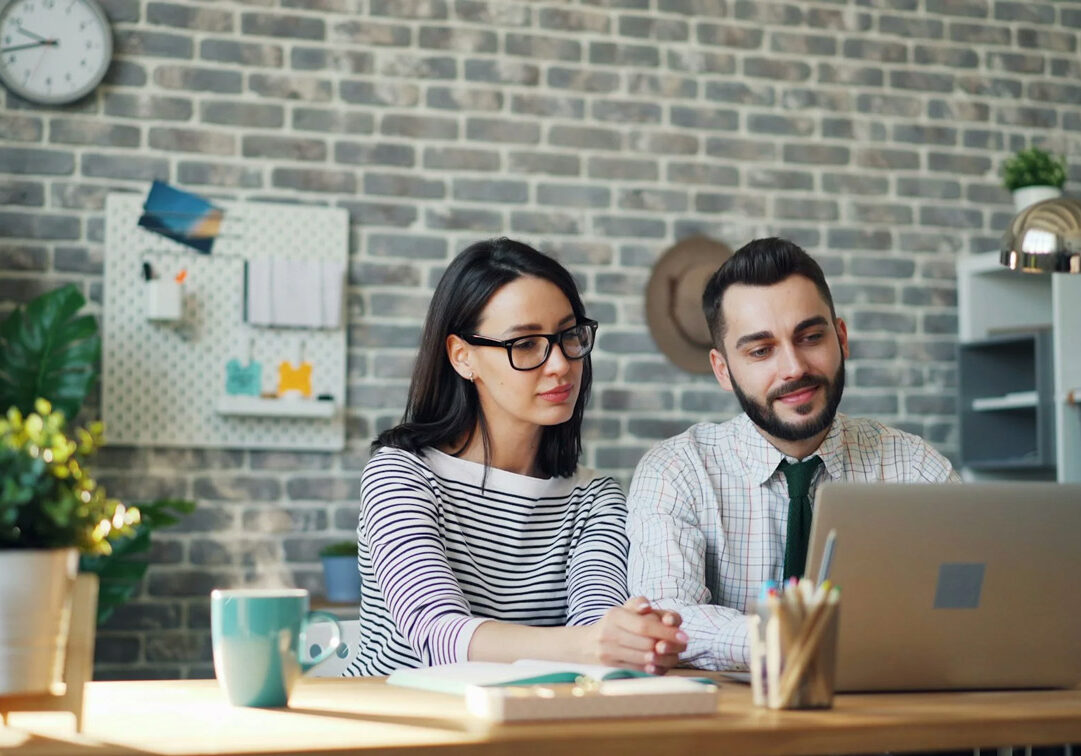 two young professionals looking at a laptop