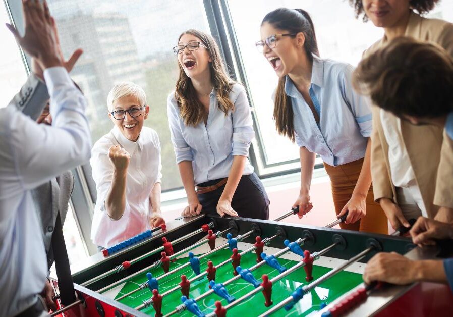 coworkers playing foosball